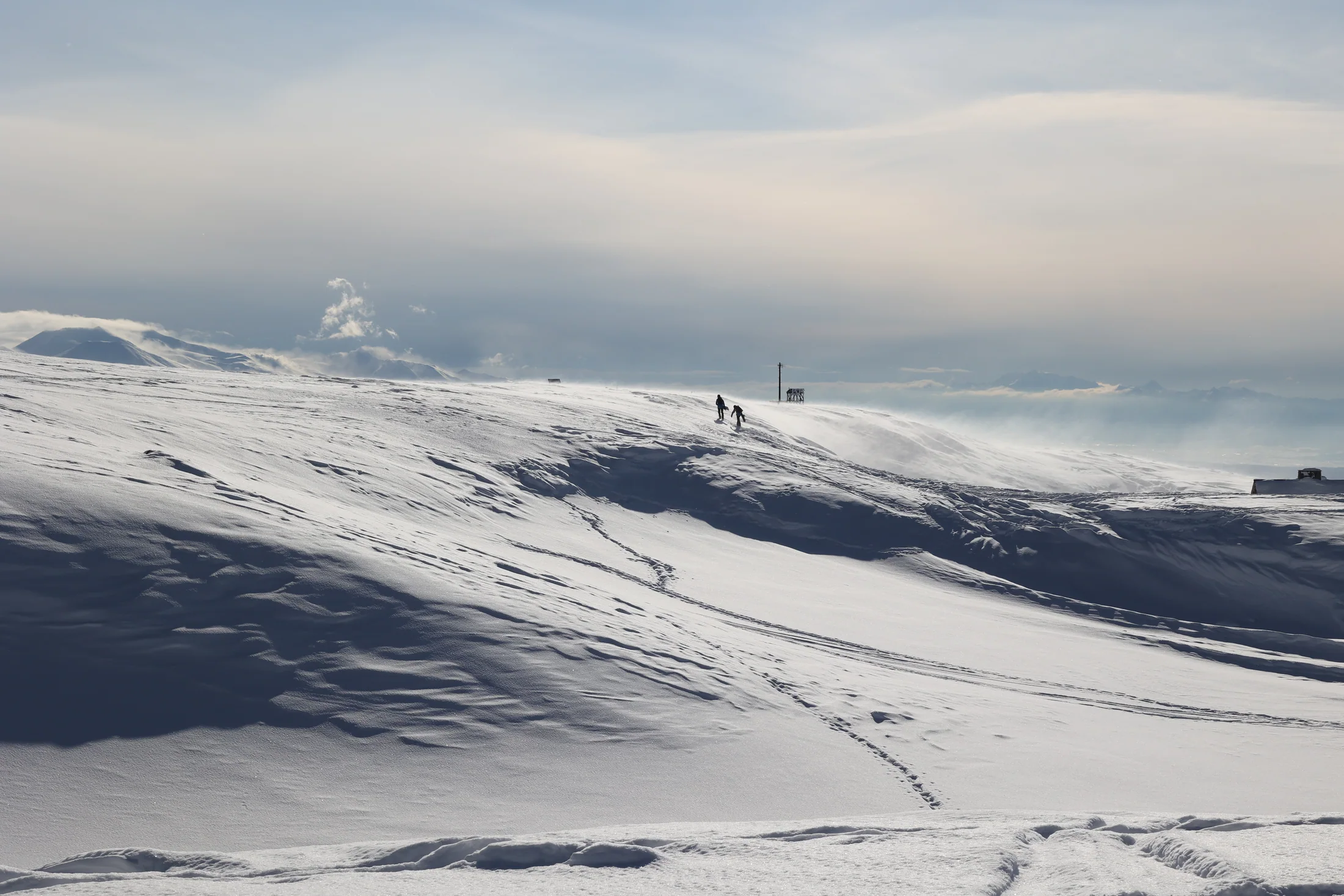 旅人走在旭岳覆雪山稜下