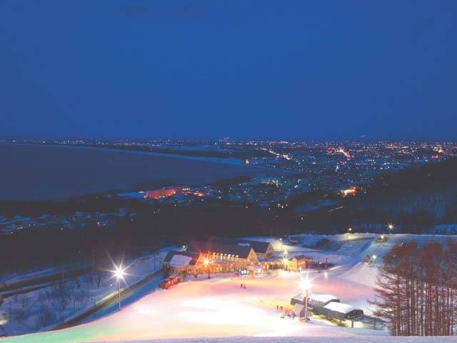 小樽 ONZE 夜間雪道、石狩灣與遠方城市燈火